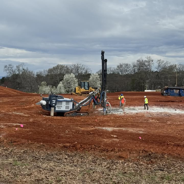 Track drill rig drilling blast holes on a graded site